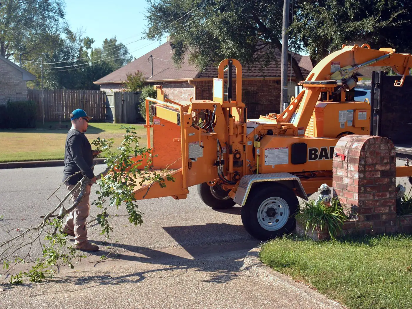 Crew loading brush into a chipper on a residential street